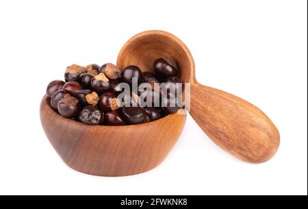 Graines de guarana dans un bol et une cuillère en bois, isolées sur fond blanc. Supplément alimentaire guarana, source de caféine pour boissons énergétiques. Banque D'Images