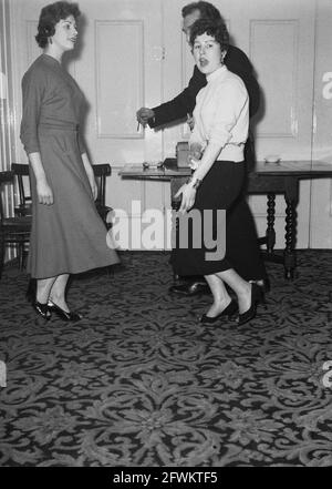 1957, historique, dans une salle de réception à l'hôtel Victoria, Leeds, un homme et deux jeunes femmes dansant, Angleterre, Royaume-Uni. Banque D'Images