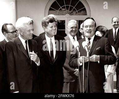 Le président John F. Kennedy rit en tant qu'acteur et comédien, Bob Hope, prononce un discours après avoir reçu la Médaille d'or du Congrès, remise par le président Kennedy en reconnaissance de ses services au pays en tant qu'animateur pendant la Seconde Guerre mondiale De gauche à droite : le sénateur Thomas H. Kuchel (Californie); le représentant Michael A. Feighan (Ohio); le président Kennedy; le sénateur Stuart Symington (Missouri); M. Hope; Dolores Hope (pour la plupart caché), épouse de M. Hope; homme non identifié. Rose Garden, Maison Blanche, Washington, D.C. Banque D'Images