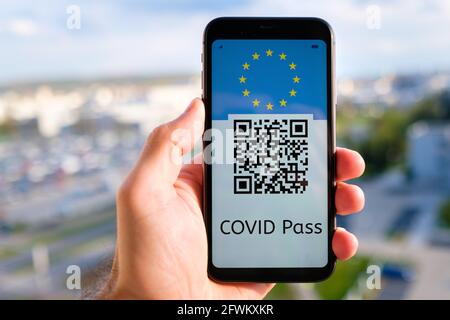 Covid Pass avec code QR avec drapeau de l'Union européenne sur l'écran dans smartphone dans la main de mans sur le fond de paysage urbain, mai 2021, San Francisco, Etats-Unis Banque D'Images