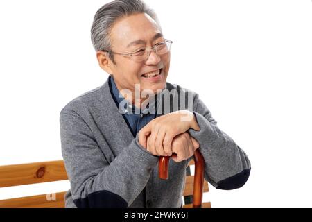 Un vieil homme heureux assis sur le banc Banque D'Images