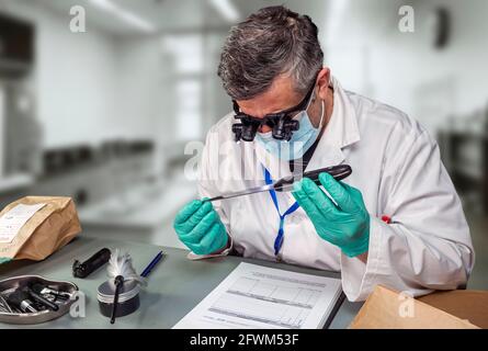 La police judiciaire analyse le couteau utilisé dans les meurtres au laboratoire de crime avec des loupes, image de concept Banque D'Images