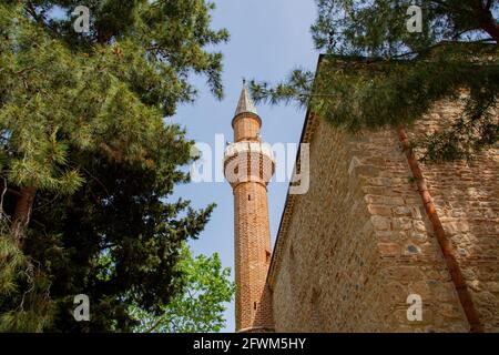 Ancienne mosquée avec un minaret en Turquie, Alanya. Mosquée parmi les arbres et ciel bleu sur le fond. Banque D'Images