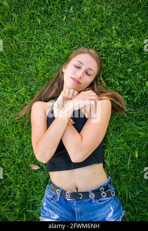 Jeune femme sur Grass sur le campus de l'université Banque D'Images