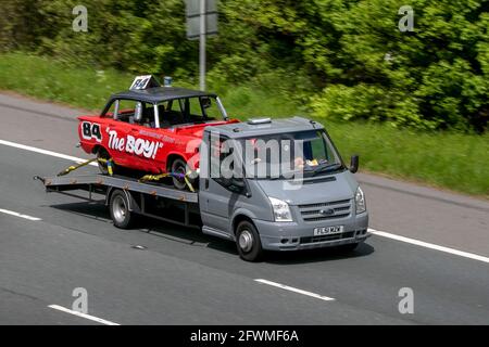 2001 Ford Transit 350 blanc LCV Haut toit van, transportant Woodgrove taxis No. 84 'The Boy' stock car conduisant sur l'autoroute M6 près de Preston UK Banque D'Images