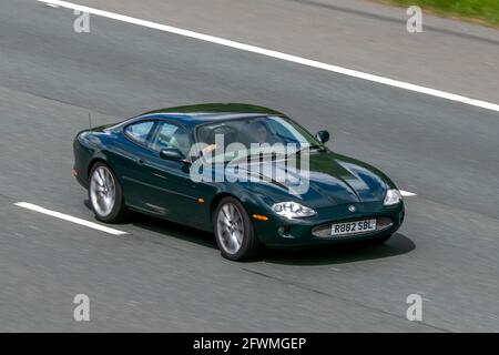 1998 90s Jaguar XK8 coupé Auto V8 Auto Green car coupé essence conduite sur l'autoroute M6 près de Preston dans Lancashire, Royaume-Uni Banque D'Images