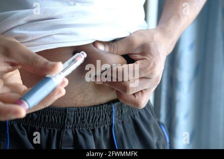 jeune homme main utilisant l'insuline stylo gros plan Banque D'Images