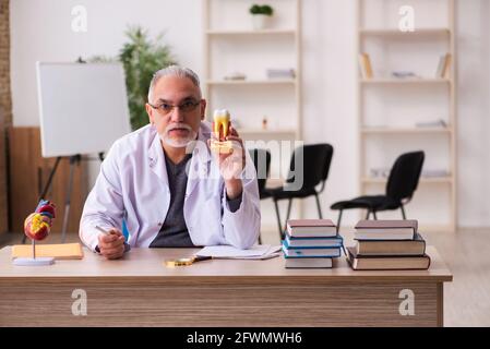 Ancien professeur de dentiste assis dans la salle de classe Banque D'Images