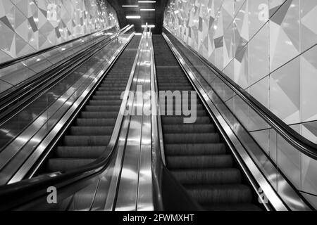 Vue à angle bas, tons noir et blanc, vue intérieure de l'escalier sur la main courante de l'escalier depuis la station de métro sans personne. Banque D'Images