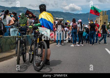 Medellin, Antioquia, Colombie. 22 mai 2021. Un démonstrateur a un drapeau colombien enveloppé sur son cou comme il a un message dans son vélo qui dit ''les protestations nous ont donné une voix, le pouvoir de vote nous donnera un changement, la résistance! Alors que les affrontements et les émeutes évoluent à Medellin, en Colombie, après les manifestants et la police anti-émeutes (ESMAD), lors d'une manifestation qui s'est transformée en affrontements après que les caméras de sécurité et le commerce aient été touchés par la manifestation. À Medellin, Antioquia, Colombie, le 22 2021. Crédit : Miyer Juana/LongVisual/ZUMA Wire/Alay Live News Banque D'Images