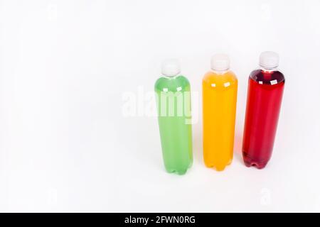 Bouteilles de boissons énergisantes aux saveurs différentes sur fond blanc. Bouteilles de jus Banque D'Images