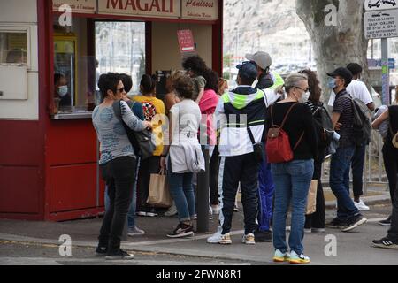 Marseille, France. 23 mai 2021. Personnes se trouvant devant un kiosque pour acheter une spécialité culinaire.au cours de la première phase de la nouvelle définition, la municipalité de Marseille a créé l'opération "la voie est libre" en interdisant la circulation des voitures sur la ruelle latérale à l'Estaque. Crédit : SOPA Images Limited/Alamy Live News Banque D'Images