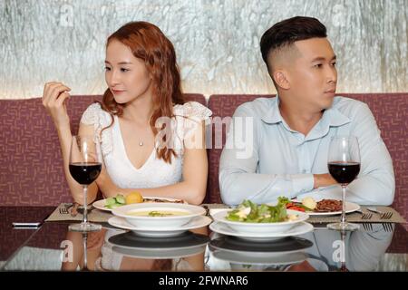 Les jeunes ayant une mauvaise première date, ils sont assis à la table du restaurant, ne parlent pas et regardent dans des directions différentes Banque D'Images