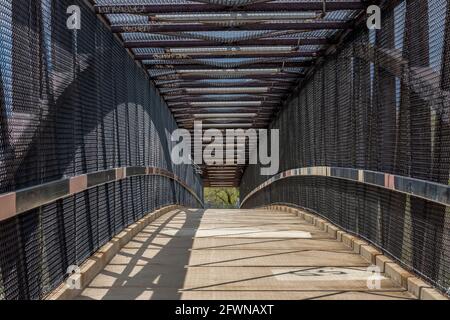 Intérieur d'un pont piétonnier moderne au-dessus d'une autoroute par une journée ensoleillée. Banque D'Images