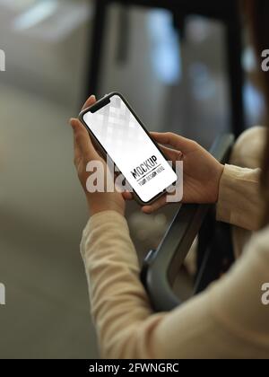Photo rognée d'une femme d'affaires à l'aide d'un smartphone dans une salle de bureau, plan d'écrêtage Banque D'Images