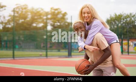 Basket-ball à dos de pigeon afro américain homme amis formation caucasienne Femme amitié multiraciale afro Guy instructeur enseignant amateurs femelle Heal Banque D'Images