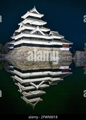 Château de Matsumoto avec son reflet dans les douves vu la nuit. La Préfecture de Nagano sur l'île de Honshu, Japon. Banque D'Images