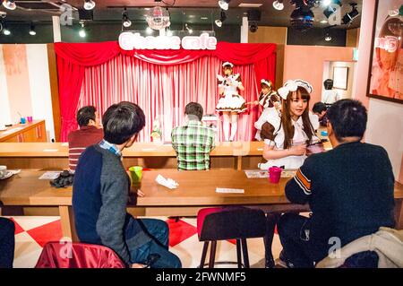 Les clients masculins regardent une performance au @home café A. Café Maid dans le quartier Akihabara de Tokyo Banque D'Images