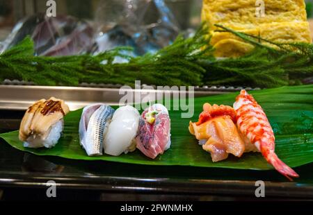 Sélection de sushis sur une feuille plate dans un restaurant dans l'ancien marché aux poissons de Tsukiji à Tokyo. Banque D'Images