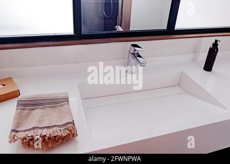 Lavabo dans l'intérieur moderne de la salle de bains, serviette et savon liquide. Banque D'Images