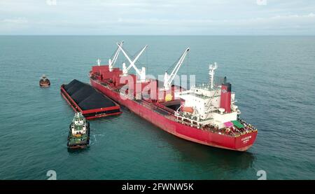 Transport du charbon de la barge à la vue aérienne du navire-mère Banque D'Images
