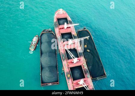 Transport du charbon de la barge à la vue aérienne du navire-mère Banque D'Images