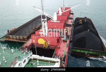 Transport du charbon de la barge à la vue aérienne du navire-mère Banque D'Images