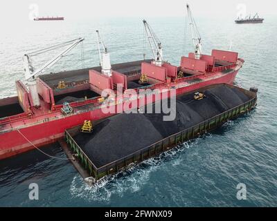 Transport du charbon de la barge à la vue aérienne du navire-mère Banque D'Images