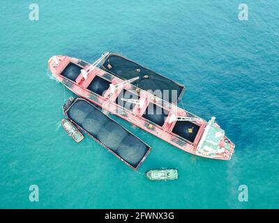 Transport du charbon de la barge à la vue aérienne du navire-mère Banque D'Images