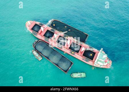 Transport du charbon de la barge à la vue aérienne du navire-mère Banque D'Images