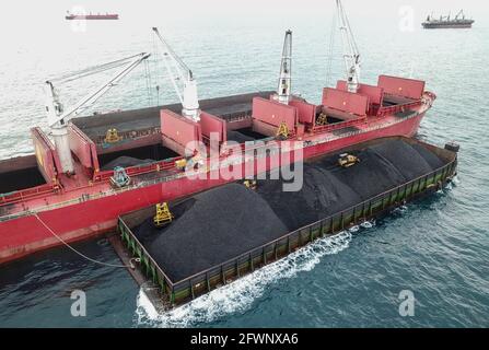 Transport du charbon de la barge à la vue aérienne du navire-mère Banque D'Images