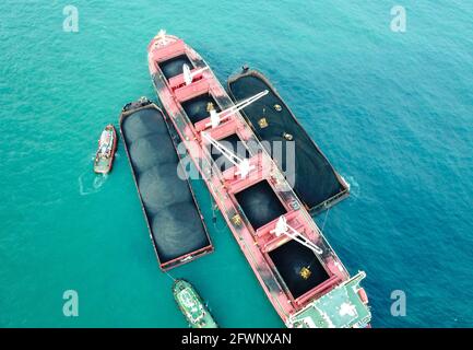 Transport du charbon de la barge à la vue aérienne du navire-mère Banque D'Images