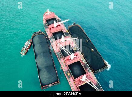 Transport du charbon de la barge à la vue aérienne du navire-mère Banque D'Images