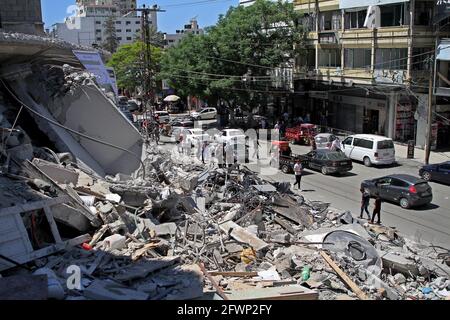 Gaza. 23 mai 2021. Les Palestiniens marchent le long des décombres de la tour Al-Shorouq détruits lors d'une attaque aérienne israélienne dans la ville de Gaza, le 23 mai 2021. Credit: Rizek Abdeljawad/Xinhua/Alamy Live News Banque D'Images