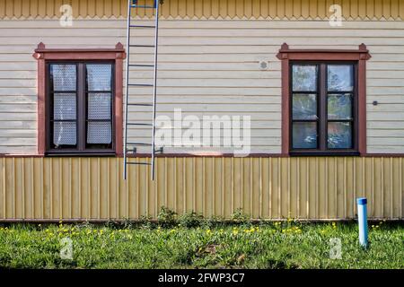 Deux fenêtres d'un ancien bâtiment en bois. Le mur est décoré avec des motifs en bois et les fermes de fenêtre sont magnifiquement sculptées. Banque D'Images