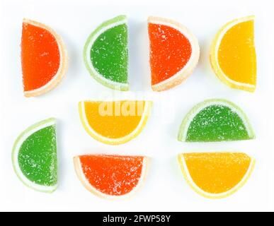 Tranches d'agrumes de marmelade multicolores en sucre sur fond blanc. Banque D'Images