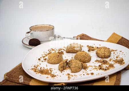 Café et biscuits, sur une plaque de couverture colorée de biscuits et une tasse de café, des biscuits de chapelure isolés Banque D'Images