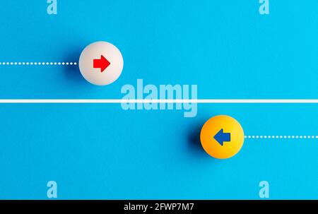 Les icônes fléchées contrastent avec les balles de tennis de table se déplaçant dans des directions opposées. Concept de concurrence, de diversité, d'opposition ou de confrontation. Banque D'Images