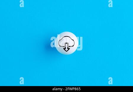 Symbole de téléchargement sur un bouton sphérique sur fond bleu. Banque D'Images