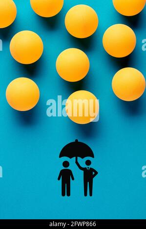 Les balles de tennis de table conçues comme des gouttes de pluie tombent sur l'icône des personnes tenant un parapluie. Concept d'assurance, de sécurité, de sécurité ou de protection. Banque D'Images