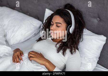 Jeune femme noire satisfaite à l'écoute de musique Banque D'Images