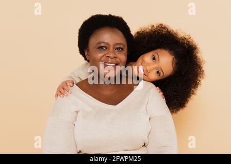 joyeuse petite-fille afro-américaine avec grand-mère isolée sur beige Banque D'Images