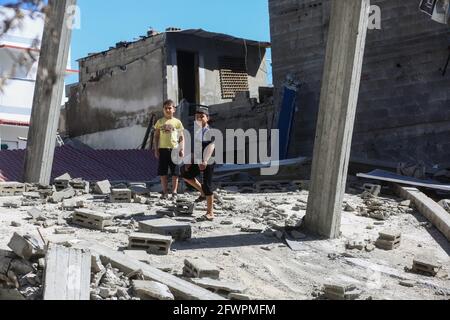 Gaza. 23 mai 2021. Des garçons palestiniens se tiennent sur les décombres d'une maison détruite lors d'une attaque aérienne israélienne dans la ville de Gaza, le 23 mai 2021. Credit: Rizek Abdeljawad/Xinhua/Alamy Live News Banque D'Images