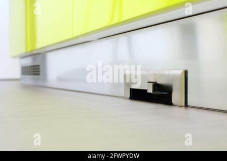 Vanne d'entrée de balayage de la pointe de l'aspirateur central intégrée à la plinthe de la cuisine. Banque D'Images