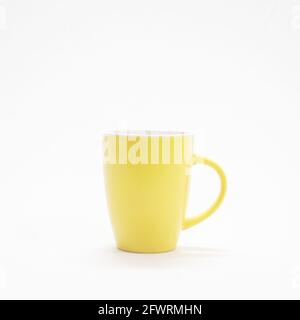 tasse à café jaune simple et simple isolée dans un blanc arrière-plan Banque D'Images