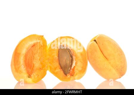 Une moitié entière et deux moitiés d'abricot ananas avec une graine, macro, isolée sur blanc. Banque D'Images