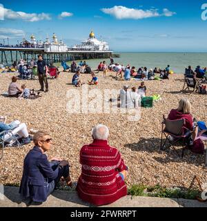 Eastbourne Beach and Pier, East Sussex, Angleterre. Une scène de plage à la hauteur de l'été anglais rempli de touristes appréciant le temps chaud. Banque D'Images