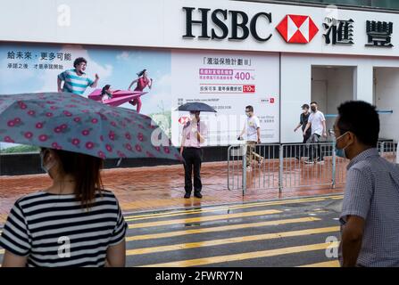 Des piétons attendent de traverser la rue devant une société britannique multinationale de services bancaires et financiers, succursale de HSBC Bank à Hong Kong. Banque D'Images