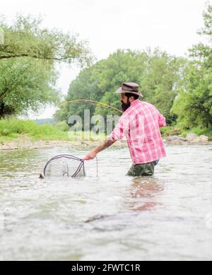 Guide de pêche et passe-temps. Les activités sportives. pothunter. week-end d'été. Pêche au gros barbu. dans l'eau. fisher pêcheur avec canne à pêche. man Banque D'Images