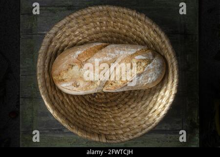 Macro Studio photo d'UN pain sur une table en bois dans un panier en osier. Vue d'en haut. Banque D'Images